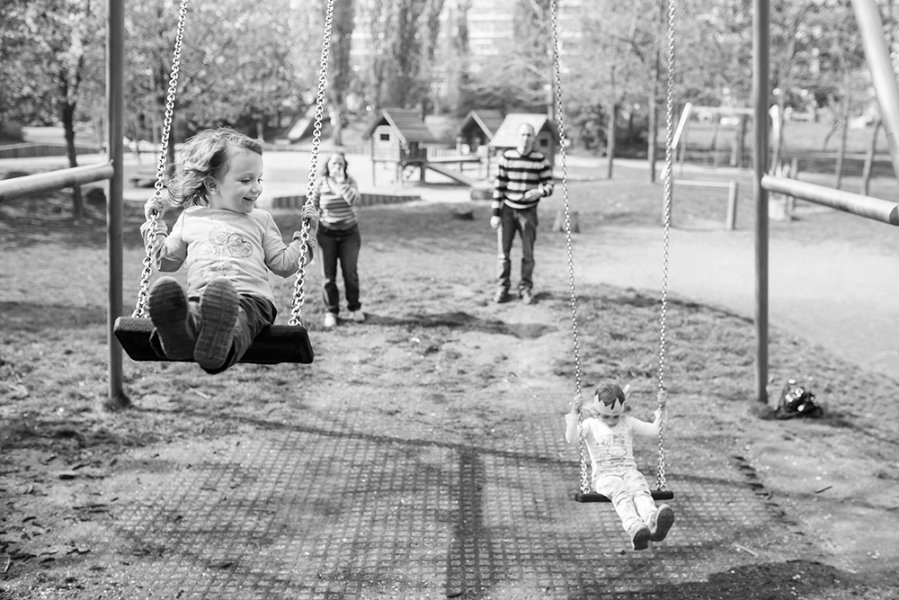 family on playground swings