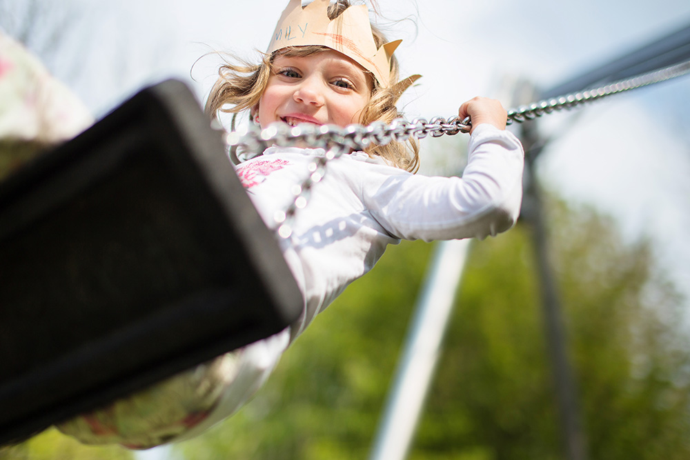 little girl with paper crown playing