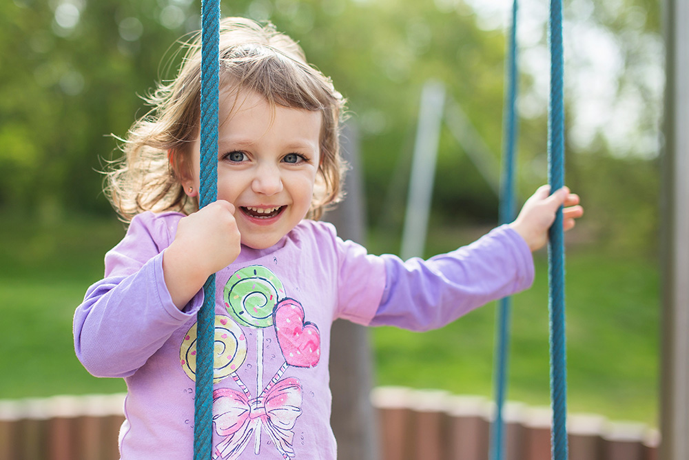 Lea climbing on playground happy