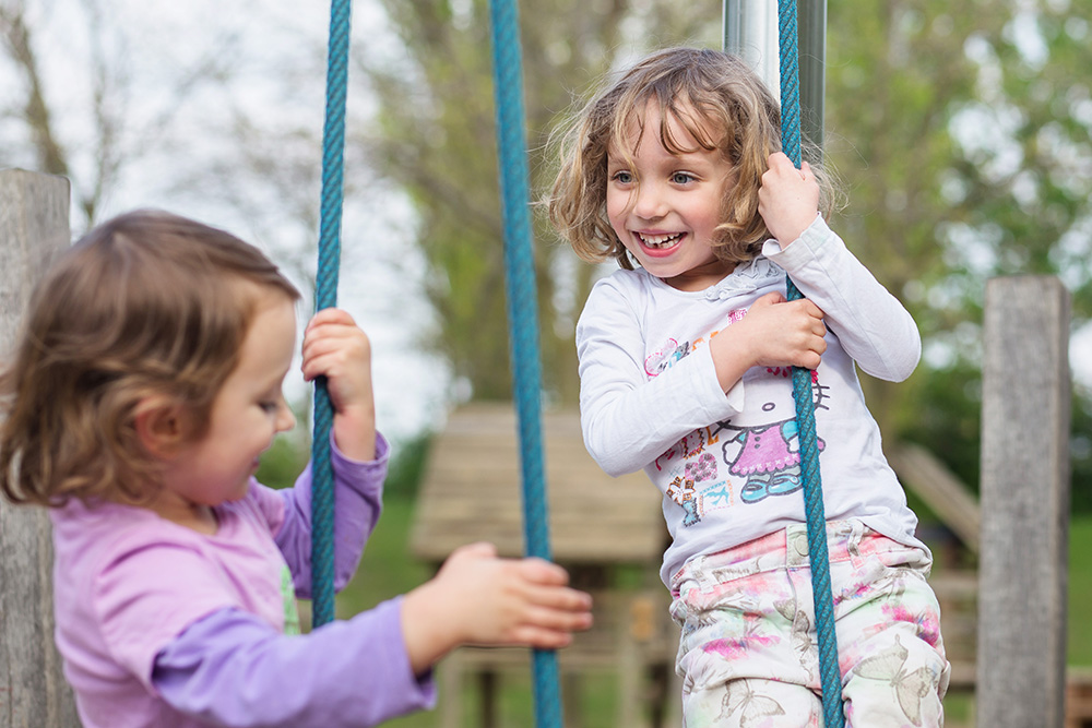 sisters playing together on playground in Leipzig