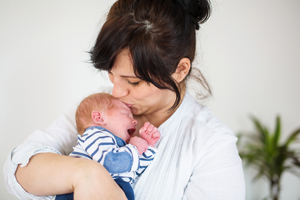 crying newborn with mom