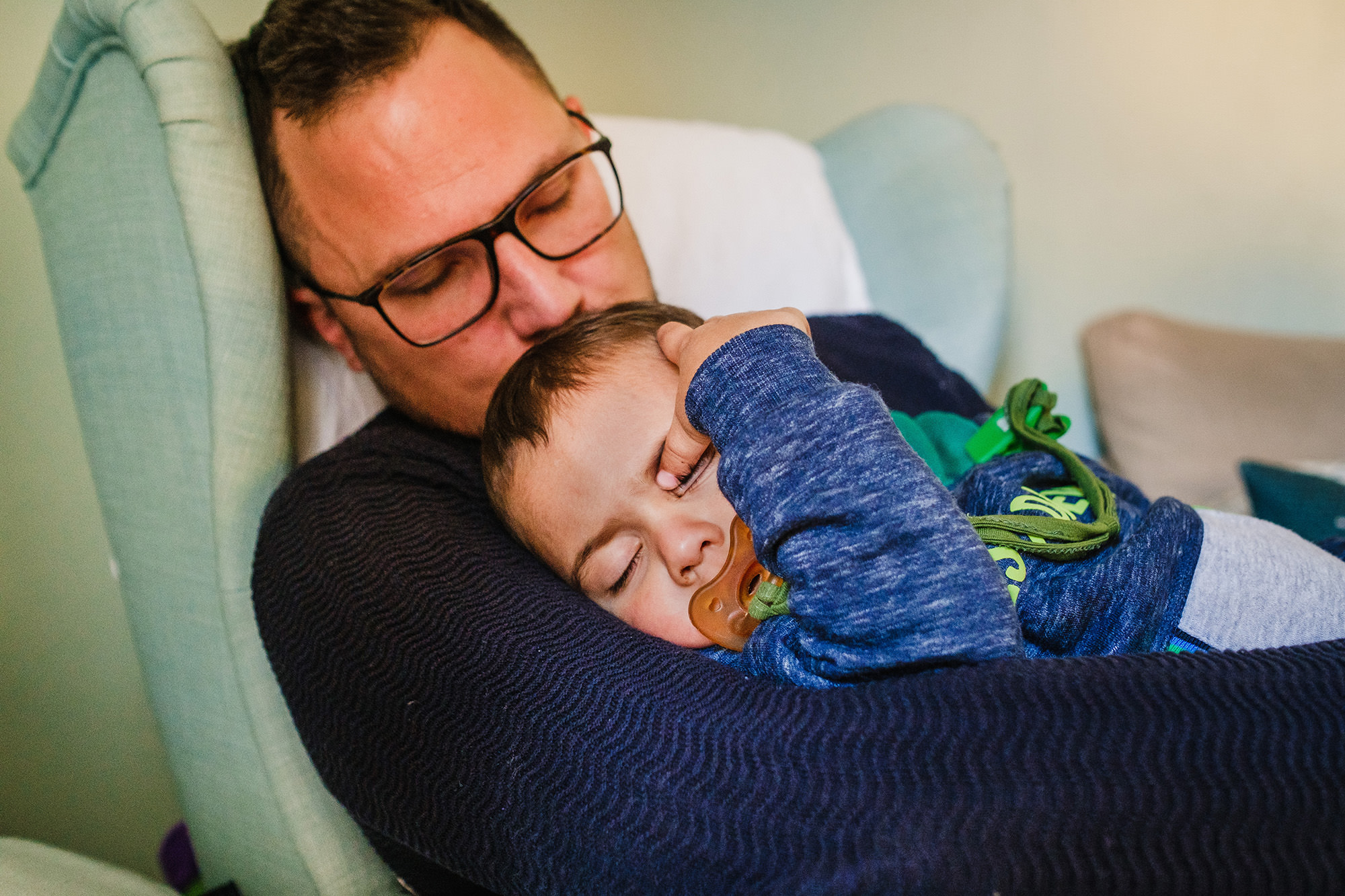 toddler sleeping in daddys arms