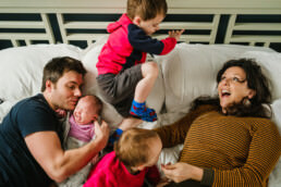 jumping on parnets bed family photo shoot