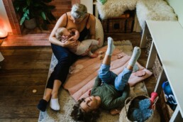 mum nursing baby with toddler son at home